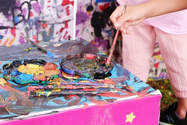 pexels-photo-35296134-35296134 A young girl creatively painting using a vibrant palette in Jakarta, Indonesia.
