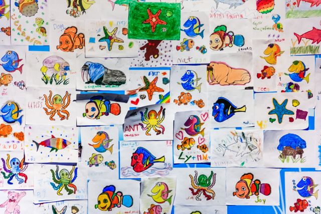 A colorful collage of children's drawings featuring various marine life in vibrant hues.